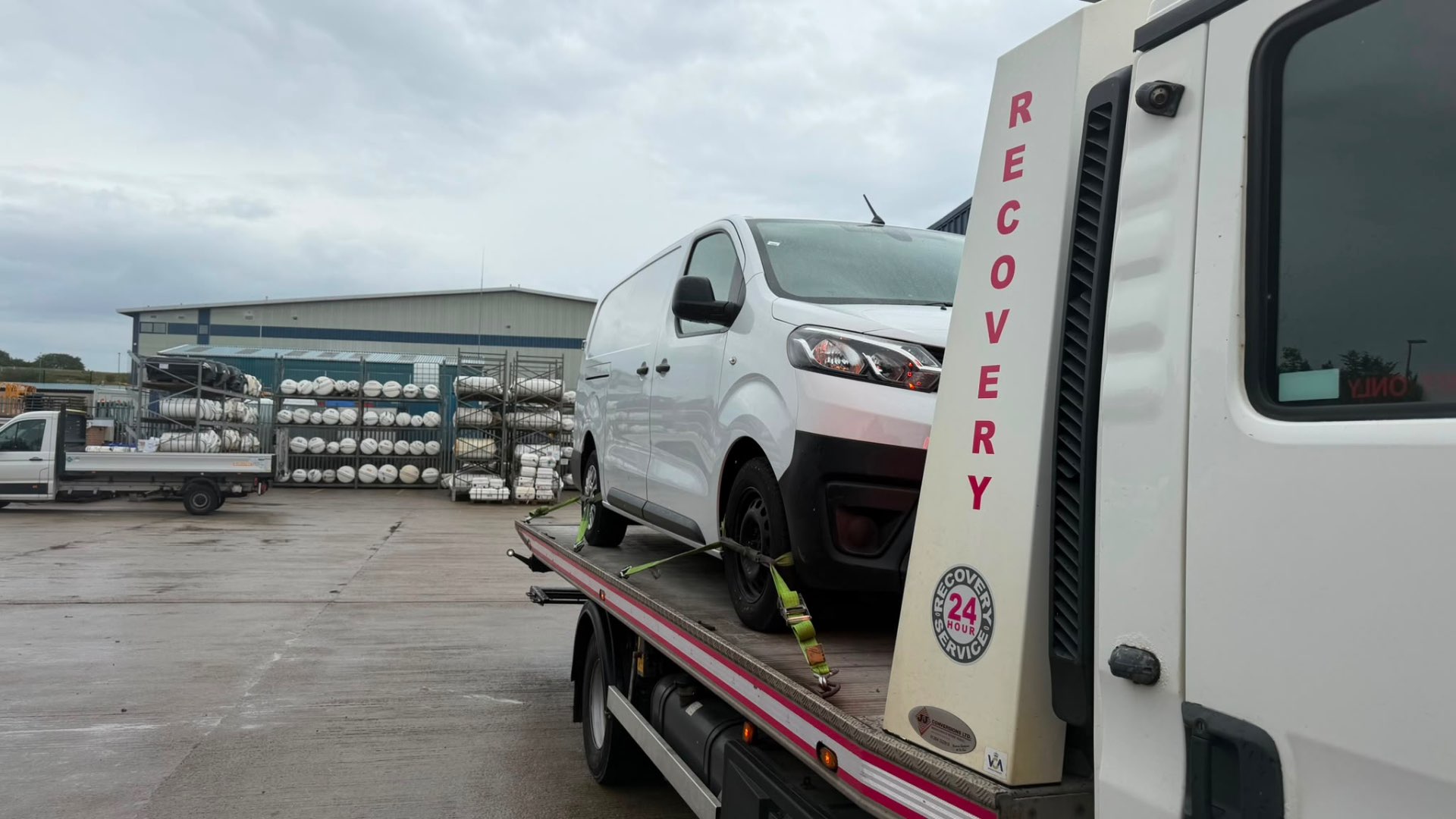 White Peugeot Expert van on MZL 24-hour recovery flatbed at industrial site