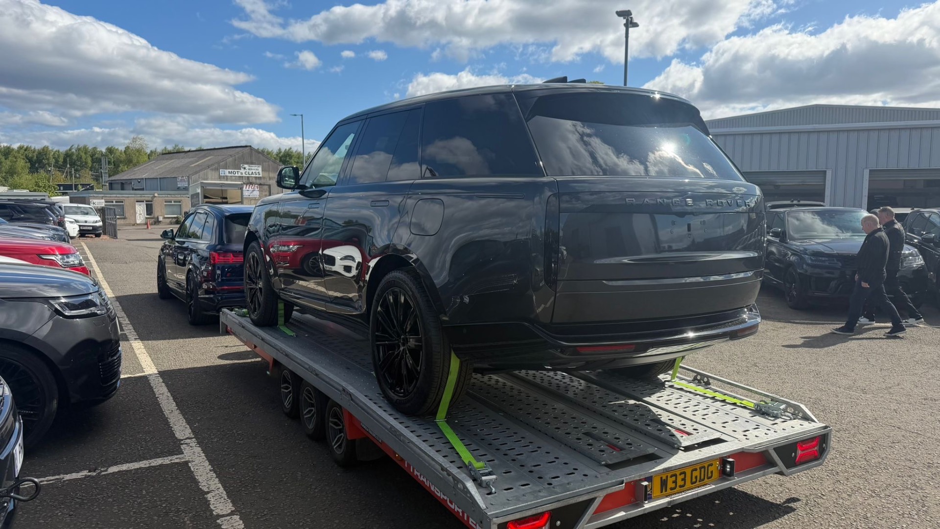 Black Range Rover loaded on covered transporter
