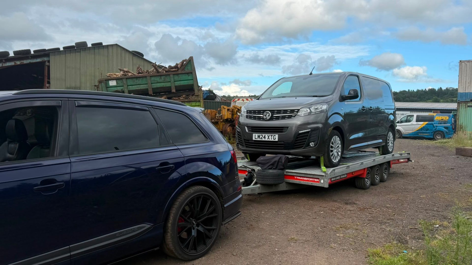 Grey Vauxhall Vivaro van on covered transporter towed by Audi SQ7