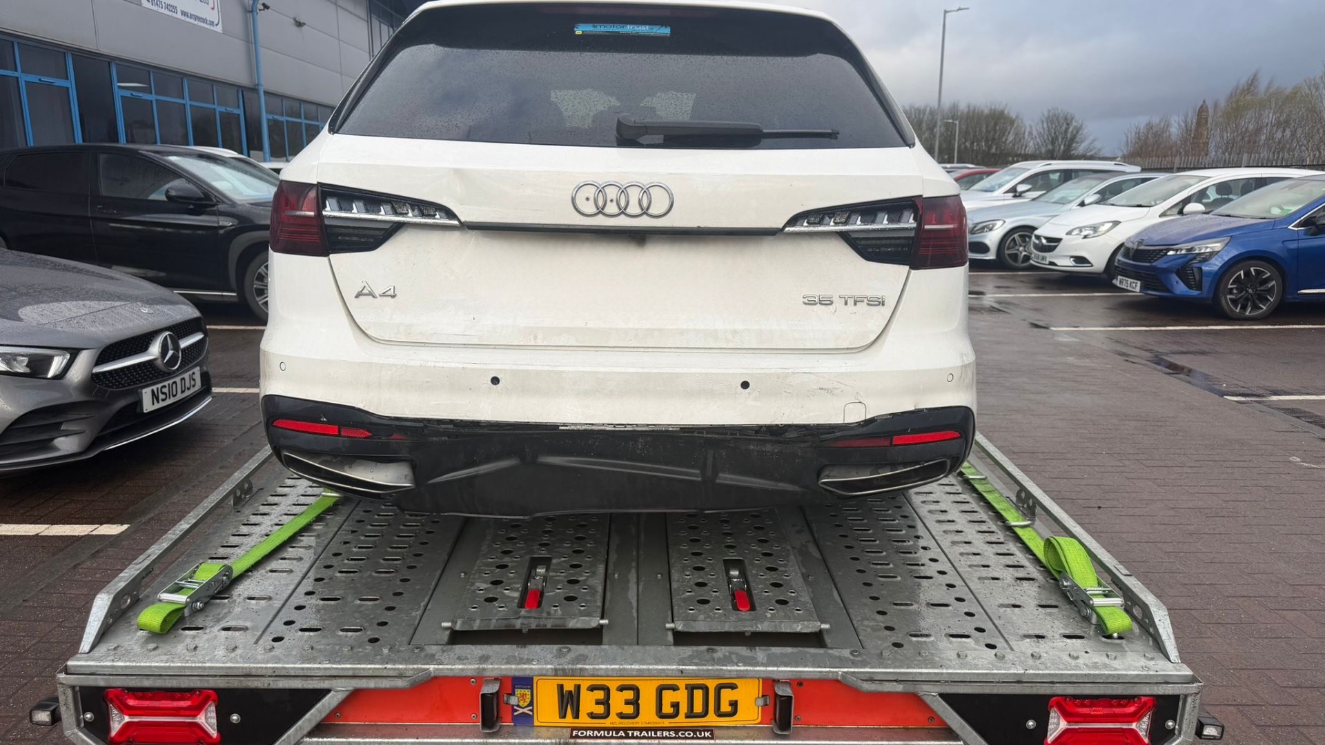 Audi A4 loaded on covered transporter