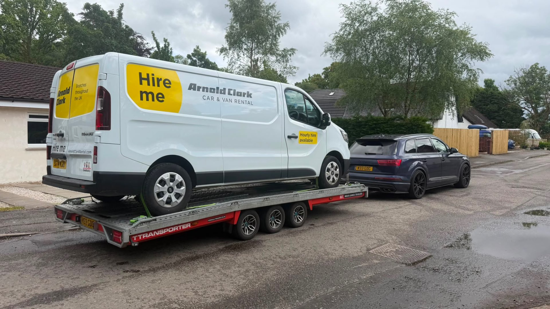 Arnold Clark hire van loaded on covered transporter towed by Audi SQ7