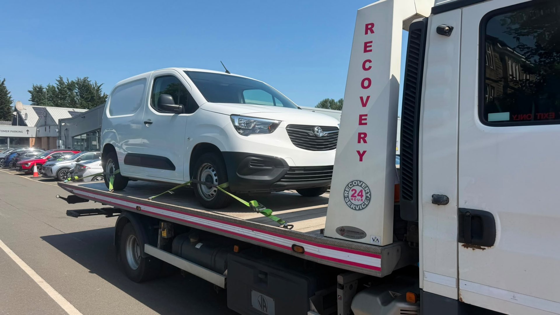 White Vauxhall Combo van loaded on MZL recovery flatbed at dealership