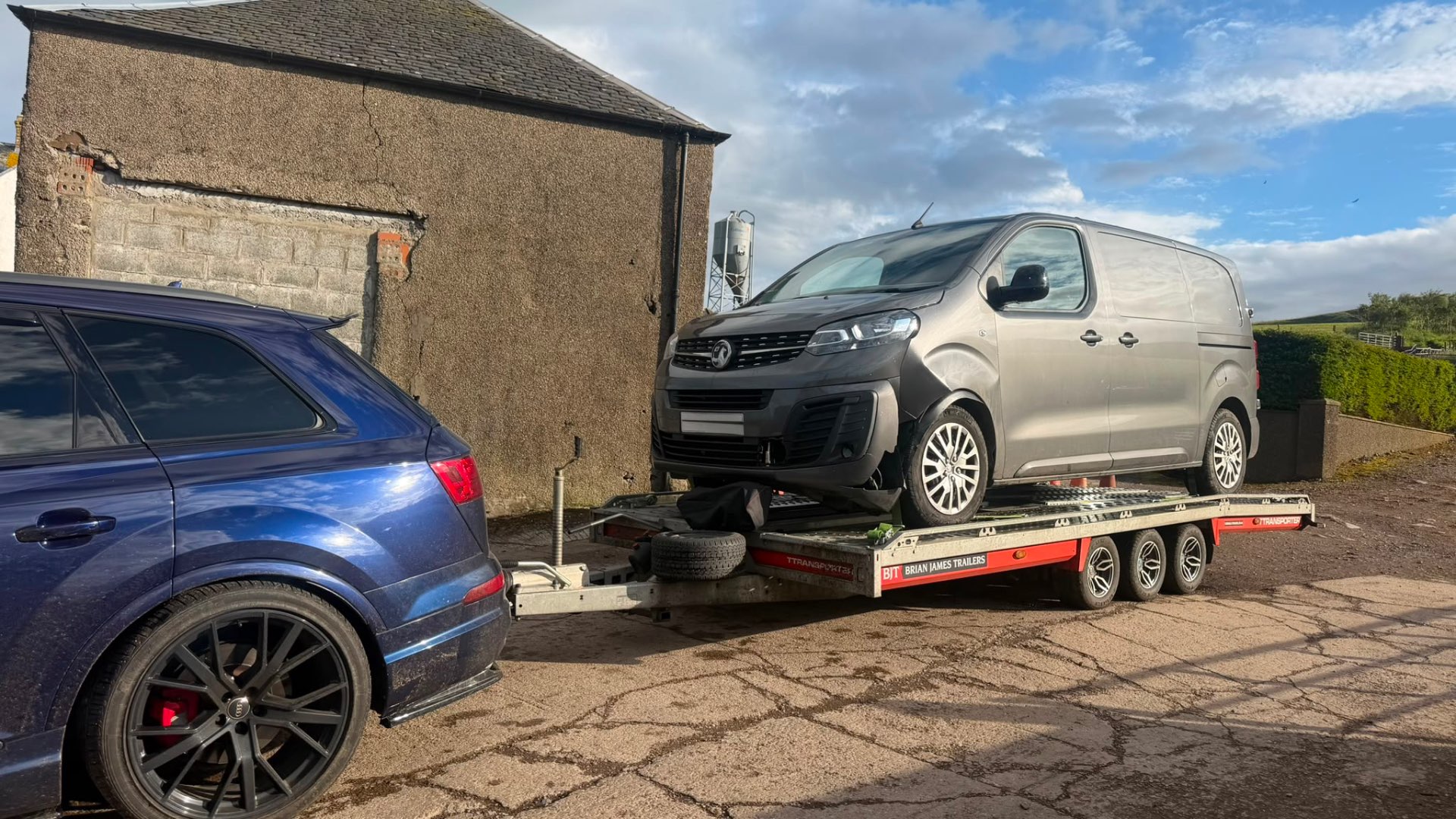 Vauxhall Vivaro van on covered transporter towed by Audi SQ7