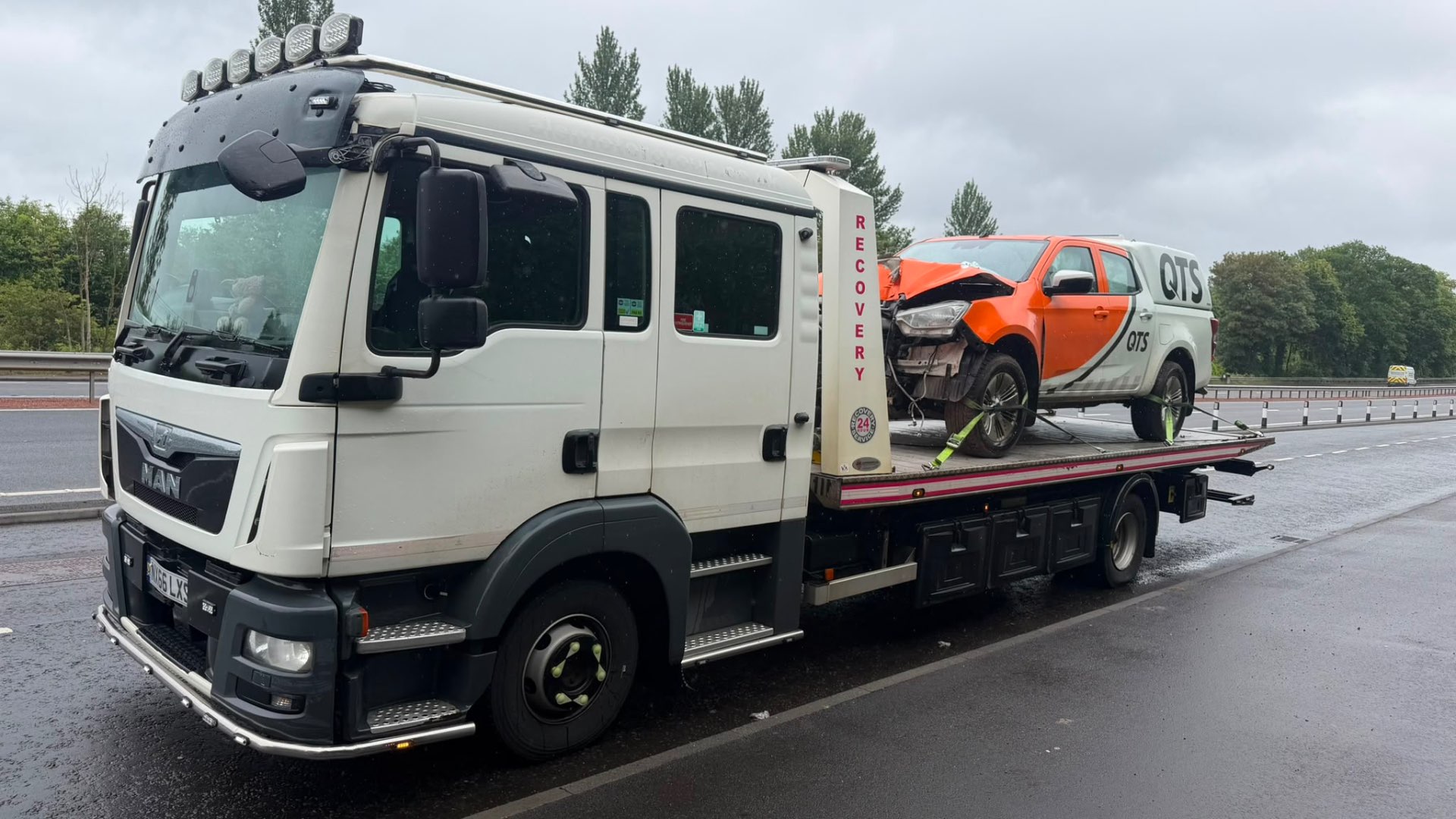 MAN recovery truck with accident-damaged QTS pickup on flatbed