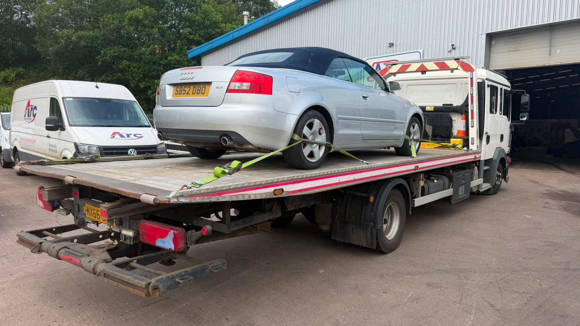 Silver Audi A4 Cabriolet on MAN recovery truck at workshop