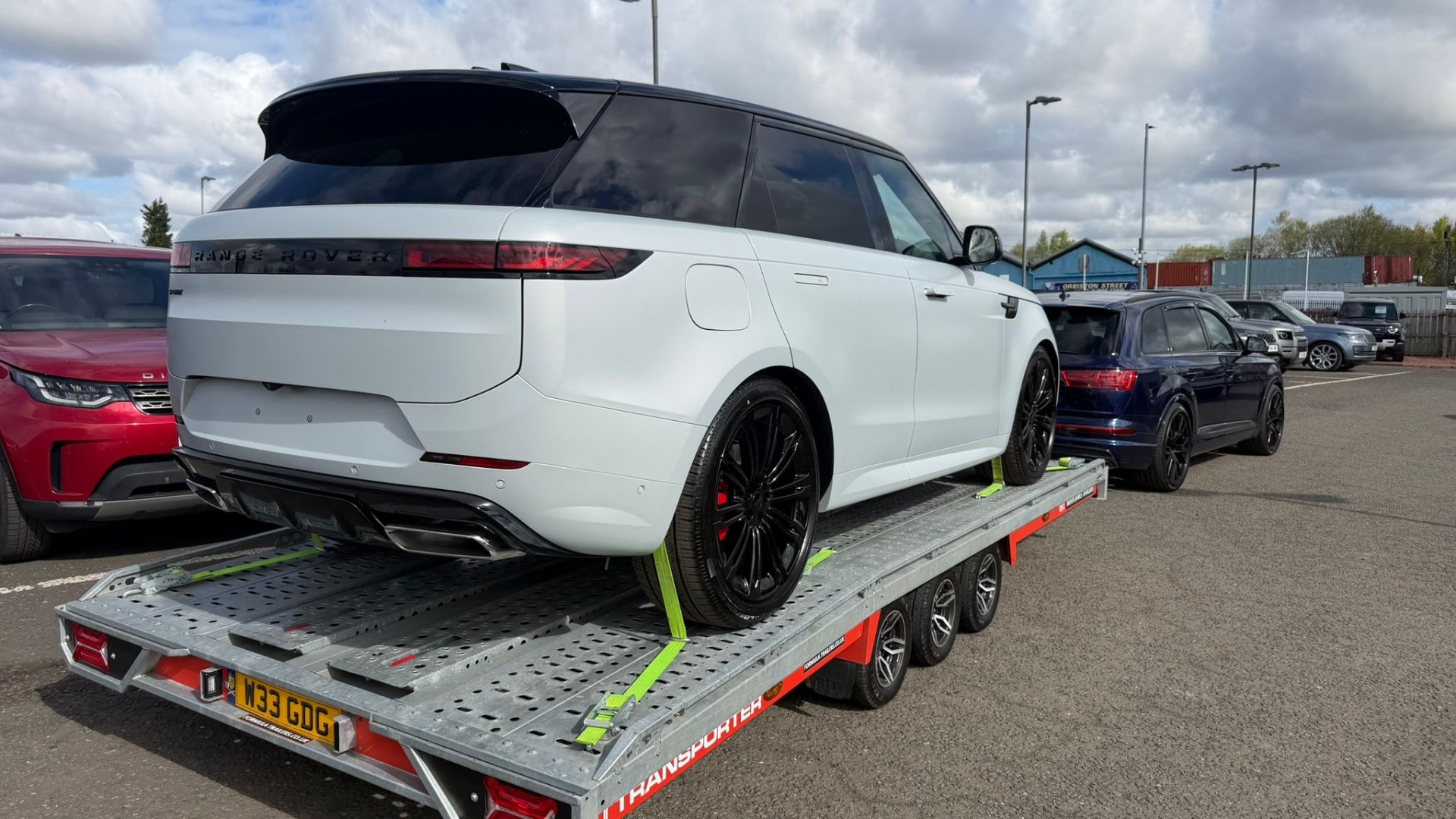 White Range Rover Sport secured on transporter