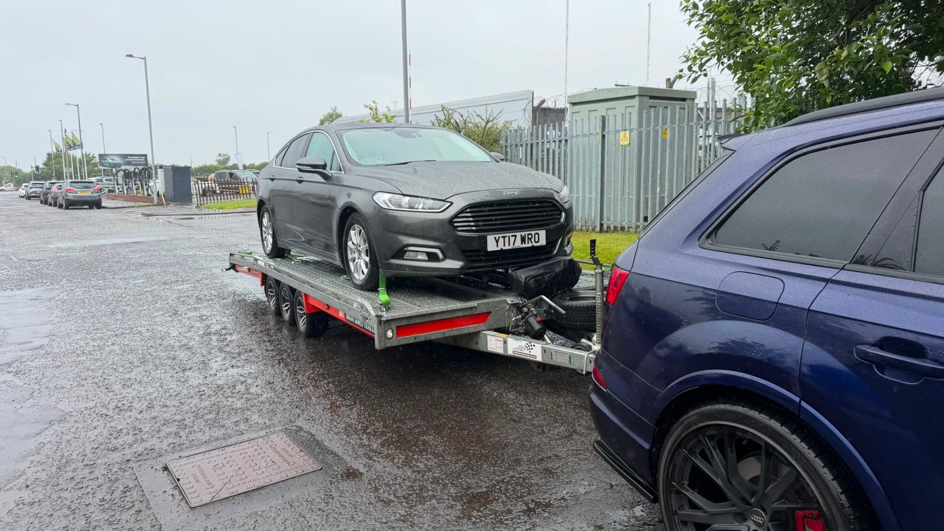Ford Mondeo loaded on transporter behind Audi SQ7 tow vehicle